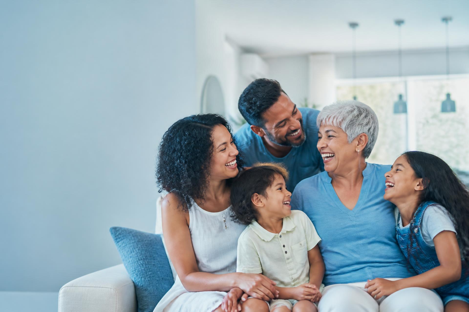 Família reunida em casa, sorrindo e cuidando uns dos outros